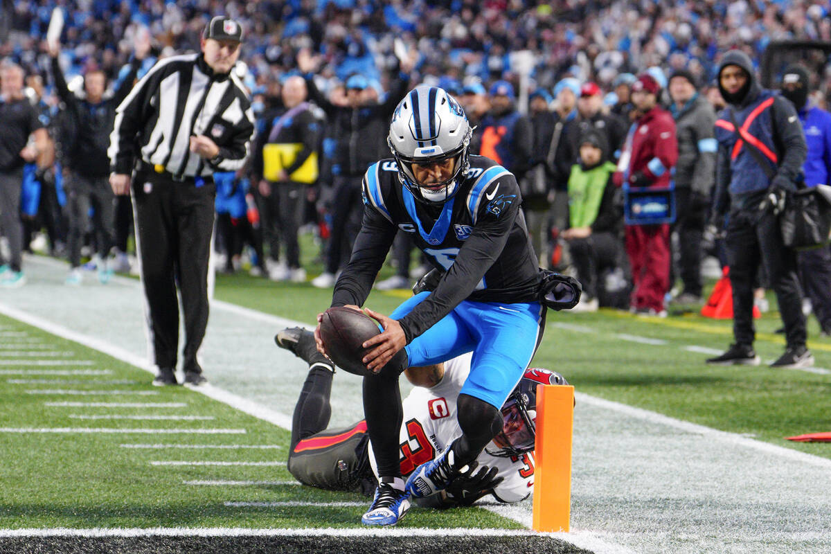 Carolina Panthers quarterback Bryce Young scores past Tampa Bay Buccaneers safety Antoine Winfi ...