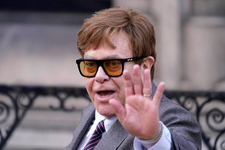 Elton John waves to the waiting media as he leaves the Royal Courts Of Justice in London, Monda ...