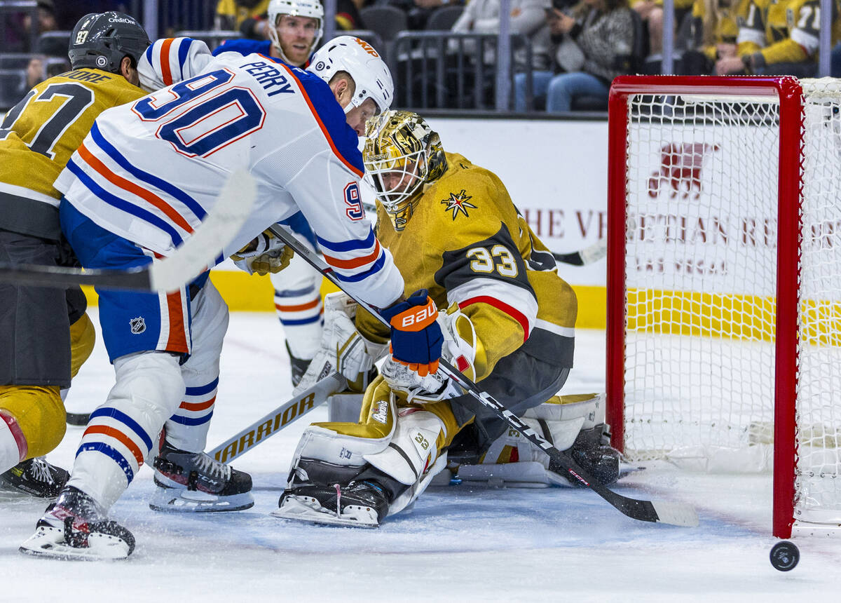 Golden Knights goaltender Adin Hill (33) and Edmonton Oilers right wing Corey Perry (90) watch ...