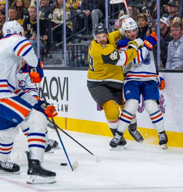 Golden Knights center Tomas Hertl (48) checks Edmonton Oilers defenseman Ty Emberson (49) into ...