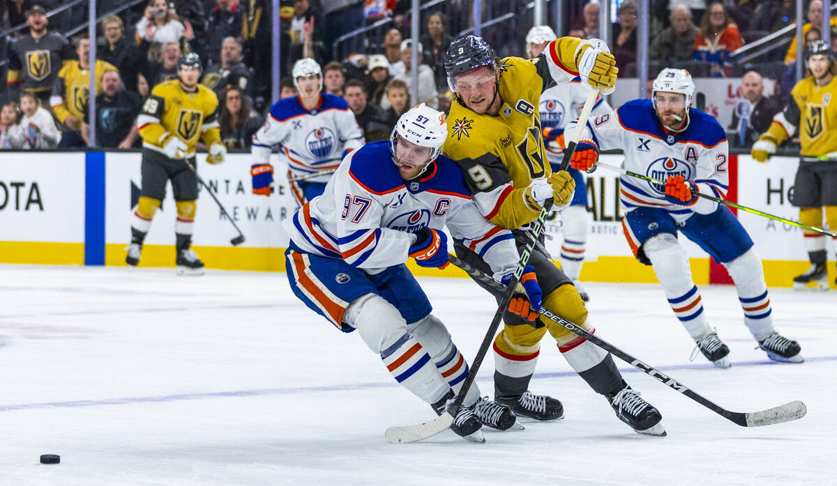 Edmonton Oilers center Connor McDavid (97) gets tangled up with Golden Knights center Jack Eich ...