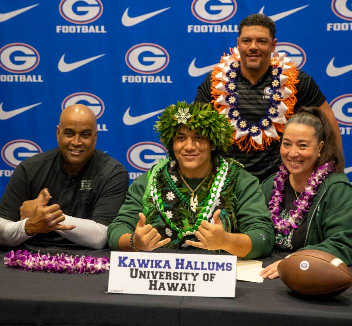 Bishop Gorman’s Kawika Hallums, center, signs a financial aid agreement with the Univers ...