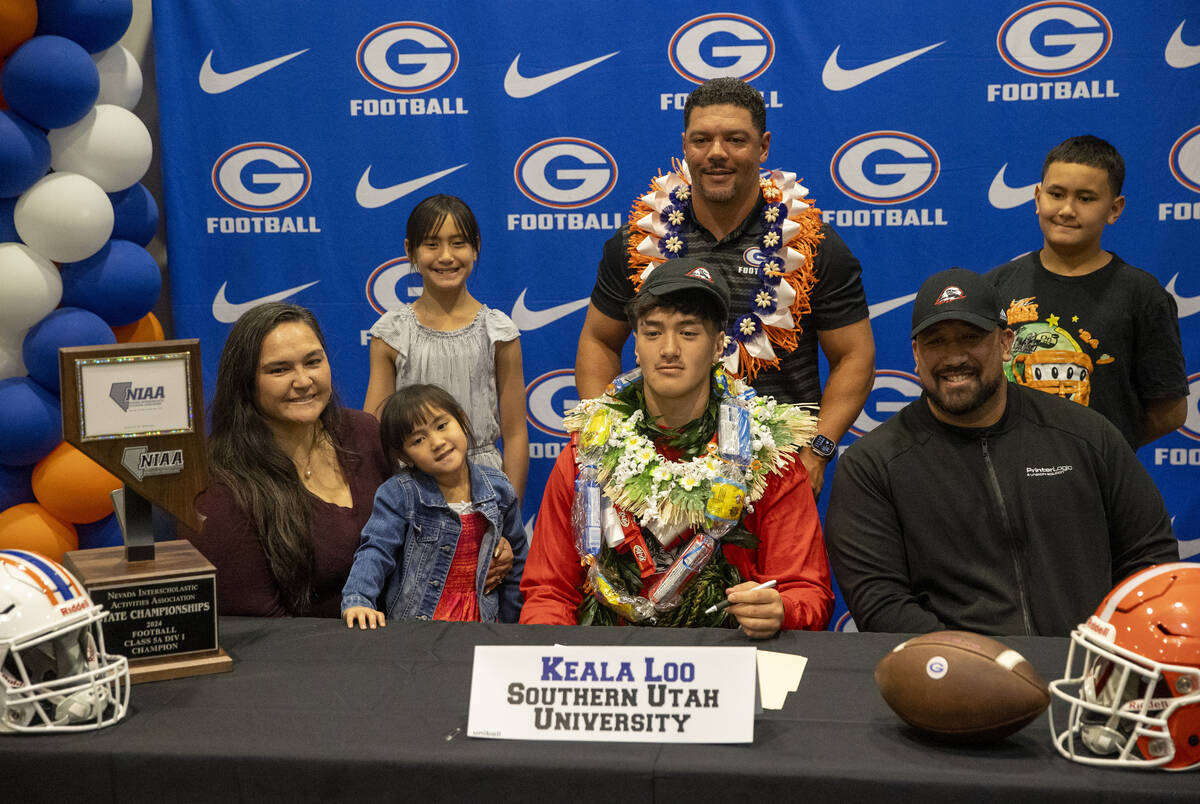 Bishop Gorman defensive lineman Keala Loo, center, signs a financial aid agreement with Souther ...