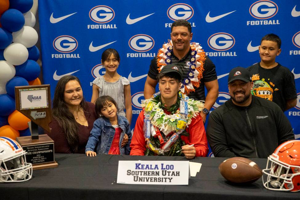 Bishop Gorman defensive lineman Keala Loo, center, signs a financial aid agreement with Souther ...