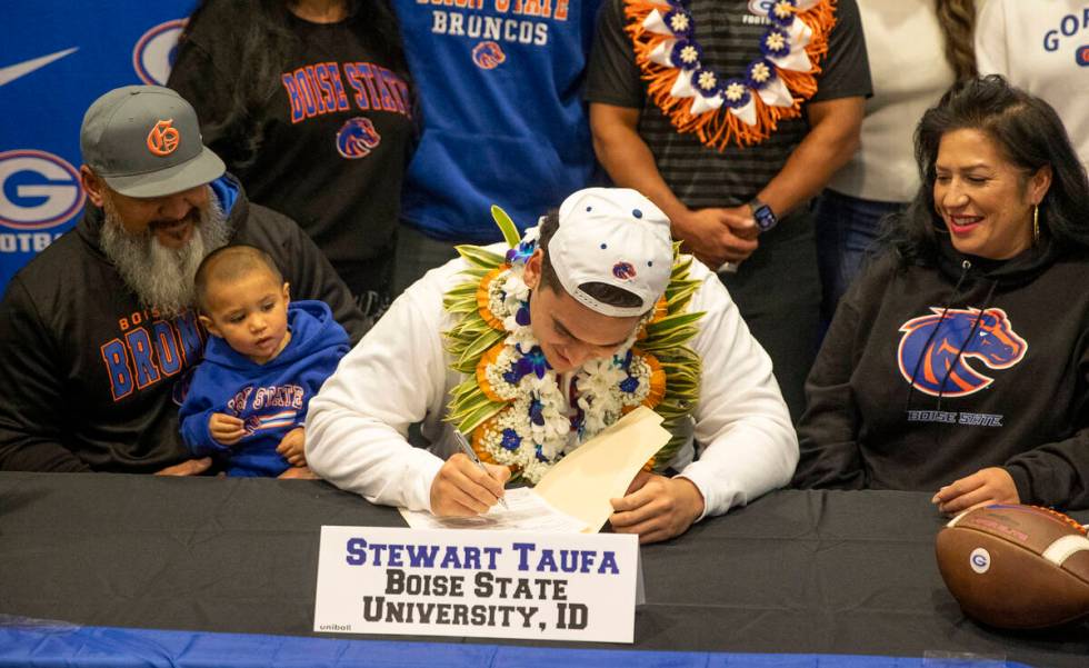 Bishop Gorman offensive lineman Stewart Taufa, center, signs a financial aid agreement with Boi ...