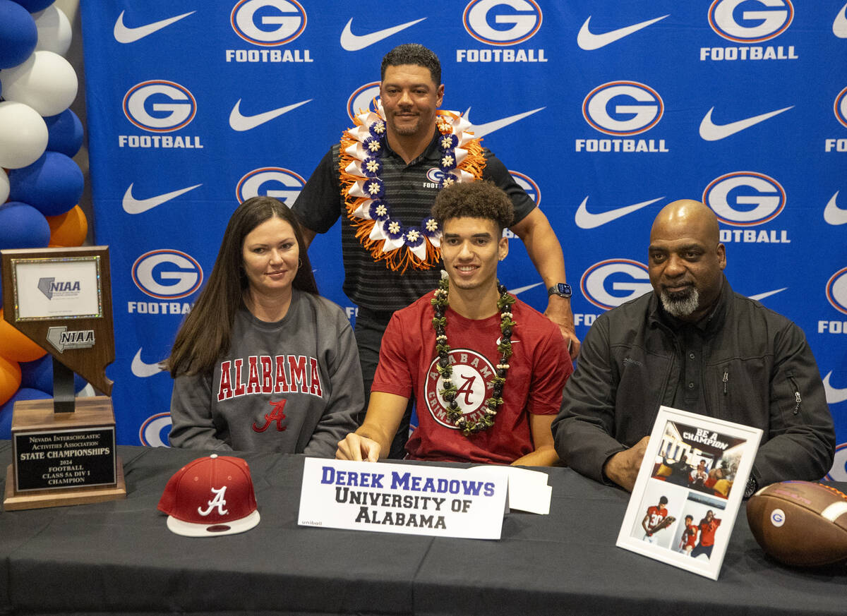 Bishop Gorman wide receiver Derek Meadows, center, signs a financial aid agreement with the Uni ...