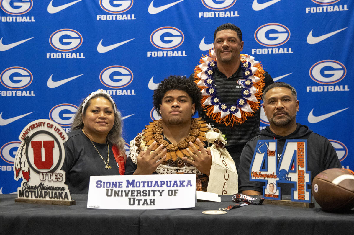 Bishop Gorman defensive tackle Sione Motuapuaka, center, signs a financial aid agreement with t ...