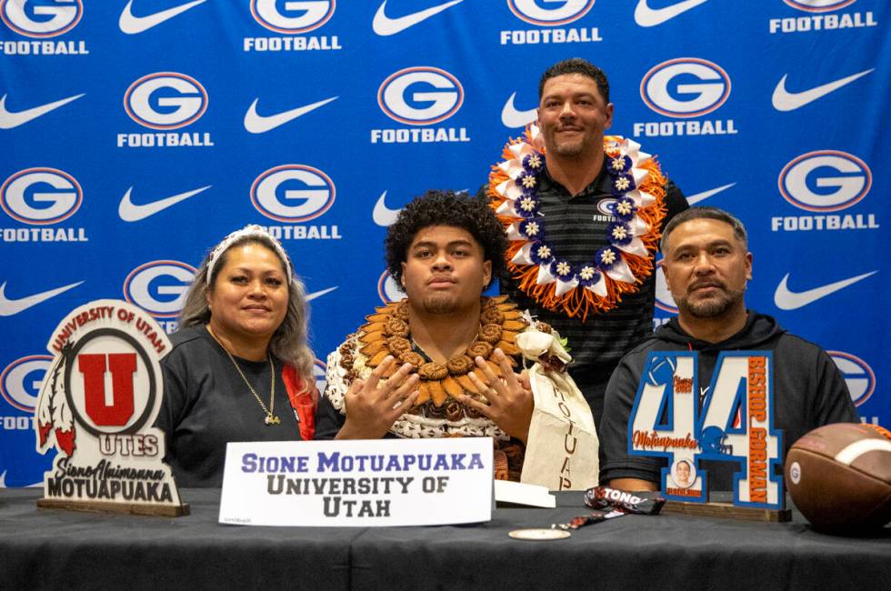 Bishop Gorman defensive tackle Sione Motuapuaka, center, signs a financial aid agreement with t ...