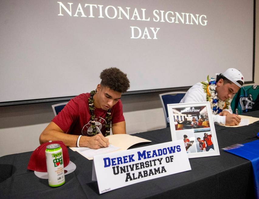 Bishop Gorman wide receiver Derek Meadows, left, signs a financial aid agreement with the Unive ...