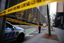 A New York police officer stands on 54th Street outside the Hilton Hotel in midtown Manhattan w ...