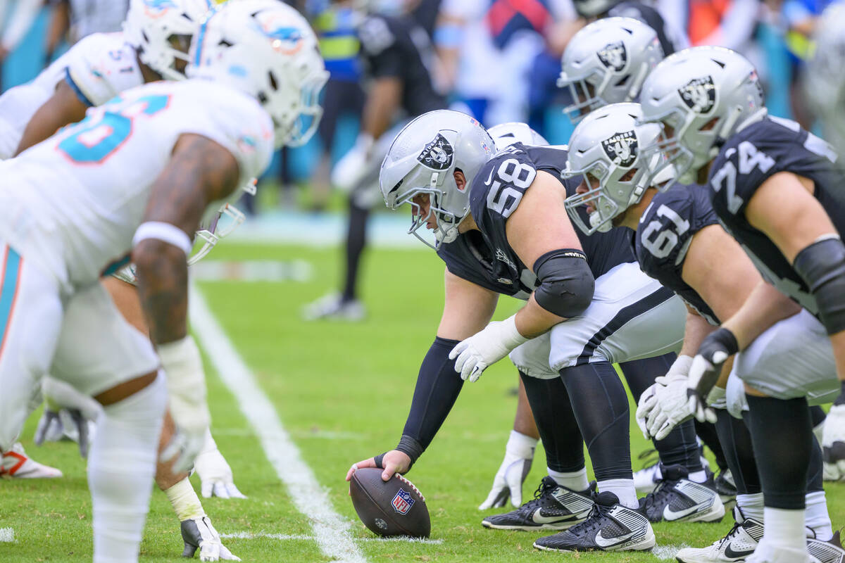 Las Vegas Raiders guard Jackson Powers-Johnson (58) prepares to hike the ball at the line of sc ...