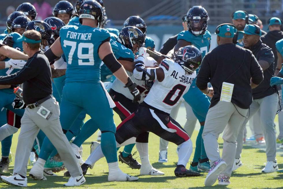 Players fight after Houston Texans linebacker Azeez Al-Shaair (0) hit Jacksonville Jaguars quar ...