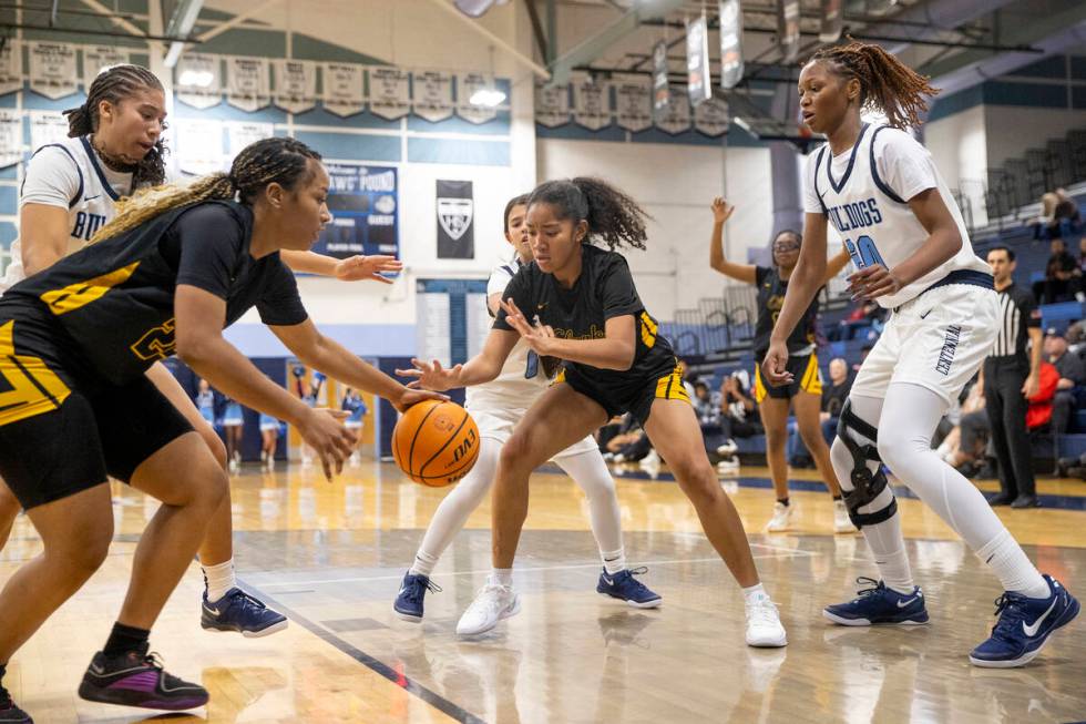 Clark and Centennial players look to grab the ball during the high school girls basketball game ...