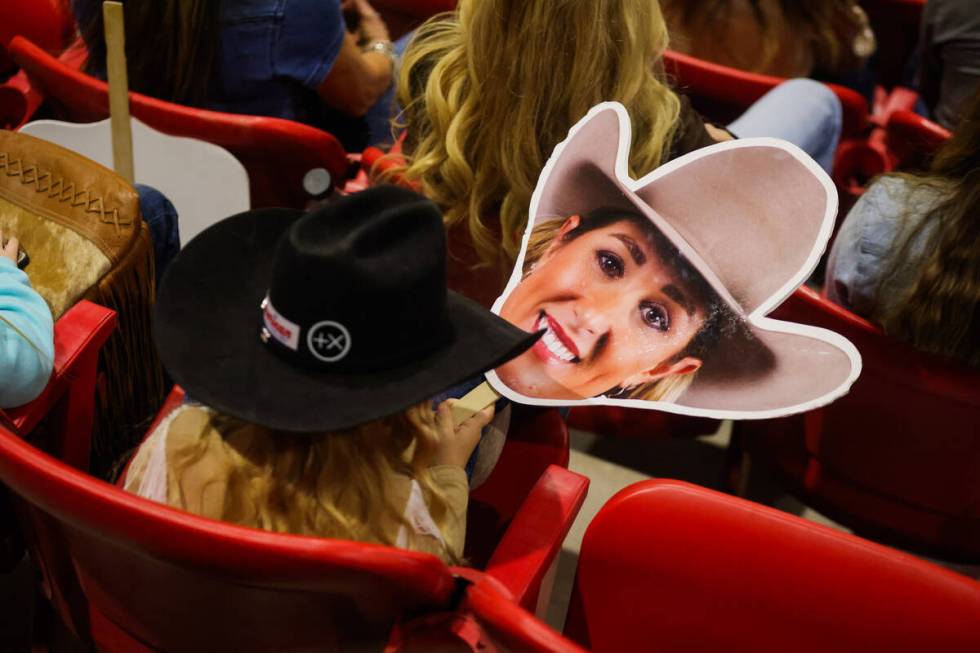 A rodeo fan holds a cardboard cutout of breakaway roper Jackie Crawford’s face during th ...