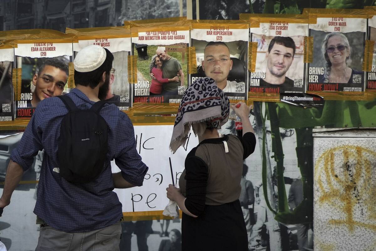 In this picture taken May 25, 2024, people looks at pictures of Hamas hostages, including Itay ...