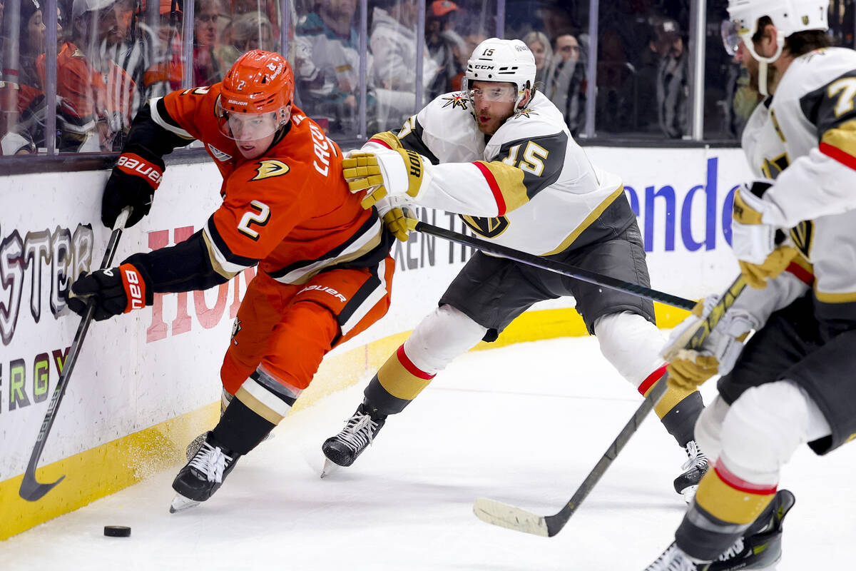 Anaheim Ducks defenseman Jackson LaCombe, left, vies for the puck with Vegas Golden Knights def ...