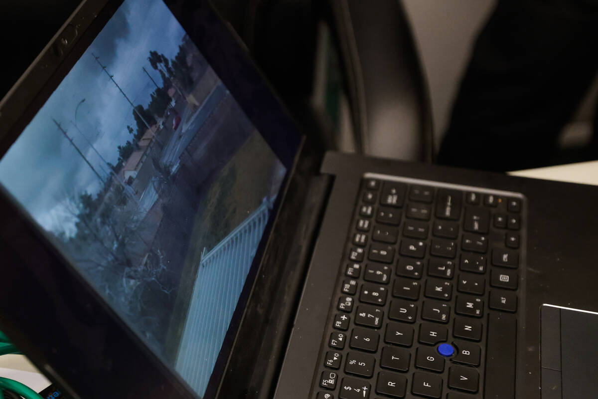 A video compilation of drivers doing doughnuts plays on a laptop during a community meeting on ...