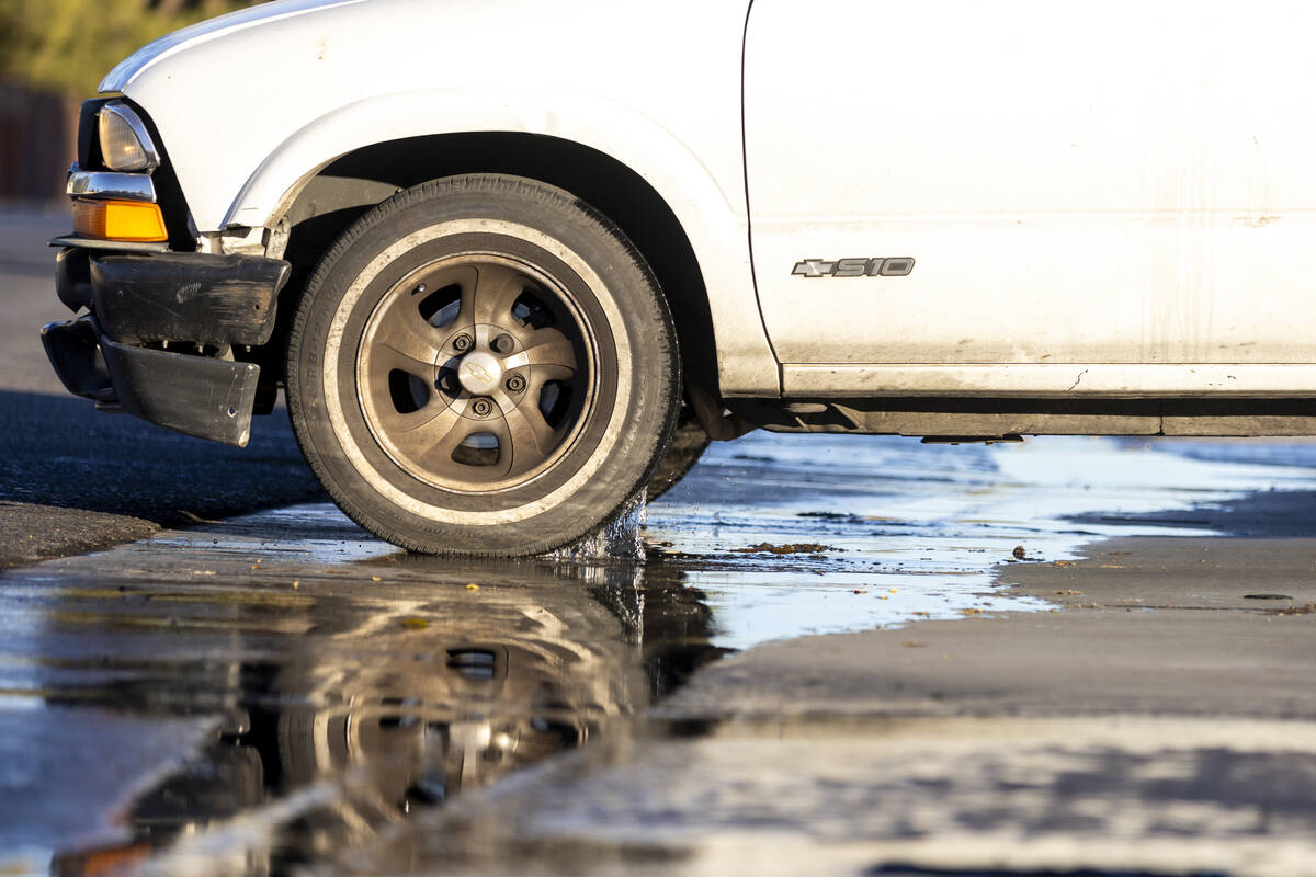 A vehicle drives through a stream of water at the intersection of East Hacienda Avenue and Sout ...