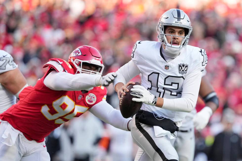 Las Vegas Raiders quarterback Aidan O'Connell (12) avoids a tackle by Kansas City Chiefs defens ...