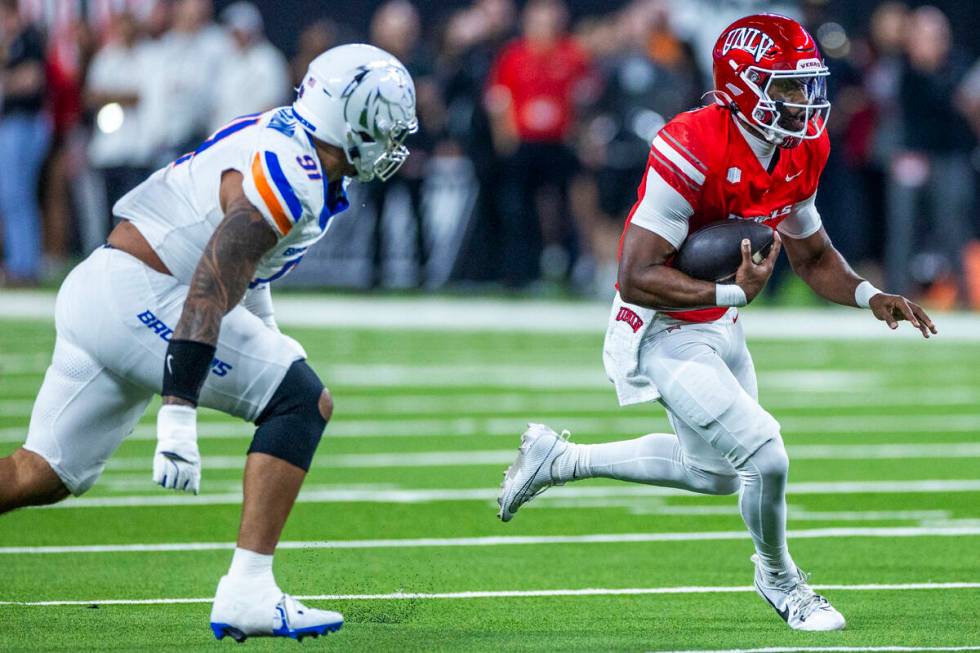 UNLV quarterback Hajj-Malik Williams (6) turns the corner on a run pursued by Boise State Bronc ...