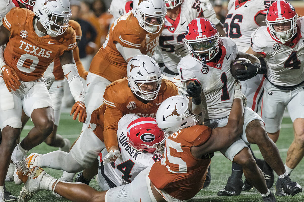 Georgia running back Trevor Etienne (1) is wrapped up by Texas defensive lineman Alfred Collins ...