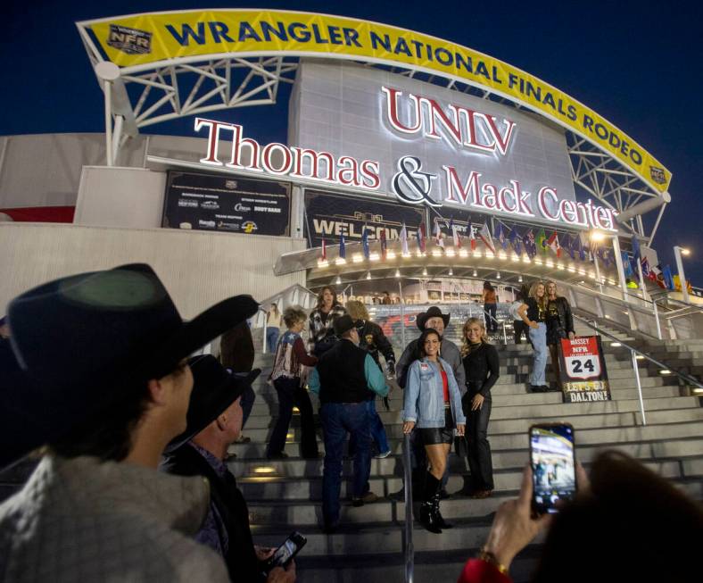 Attendees take photographs before opening night of the National Finals Rodeo outside the Thomas ...