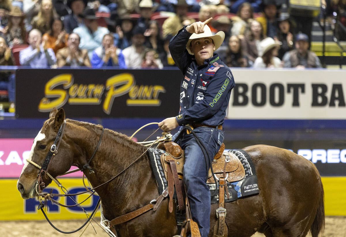 Riley Mason Webb points to the crowd after competing in the tie-down roping event during openin ...