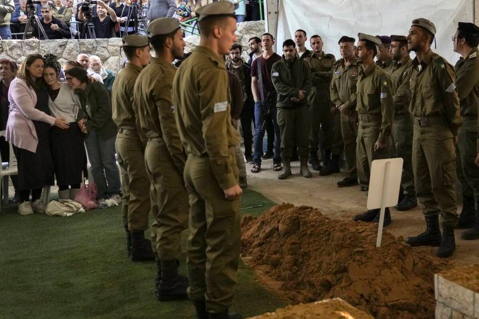 Close relatives, left, of combat engineer squad commander Staff Sgt. Zamir Burke, 20, from Beit ...