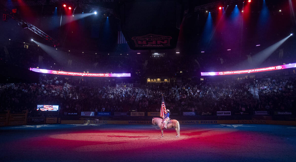 The American flag is presented during opening night of the National Finals Rodeo at the Thomas ...