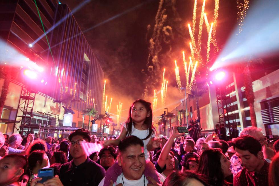 Anika Begay sits on her father Brian Begay's shoulders while watching a light and fireworks sho ...