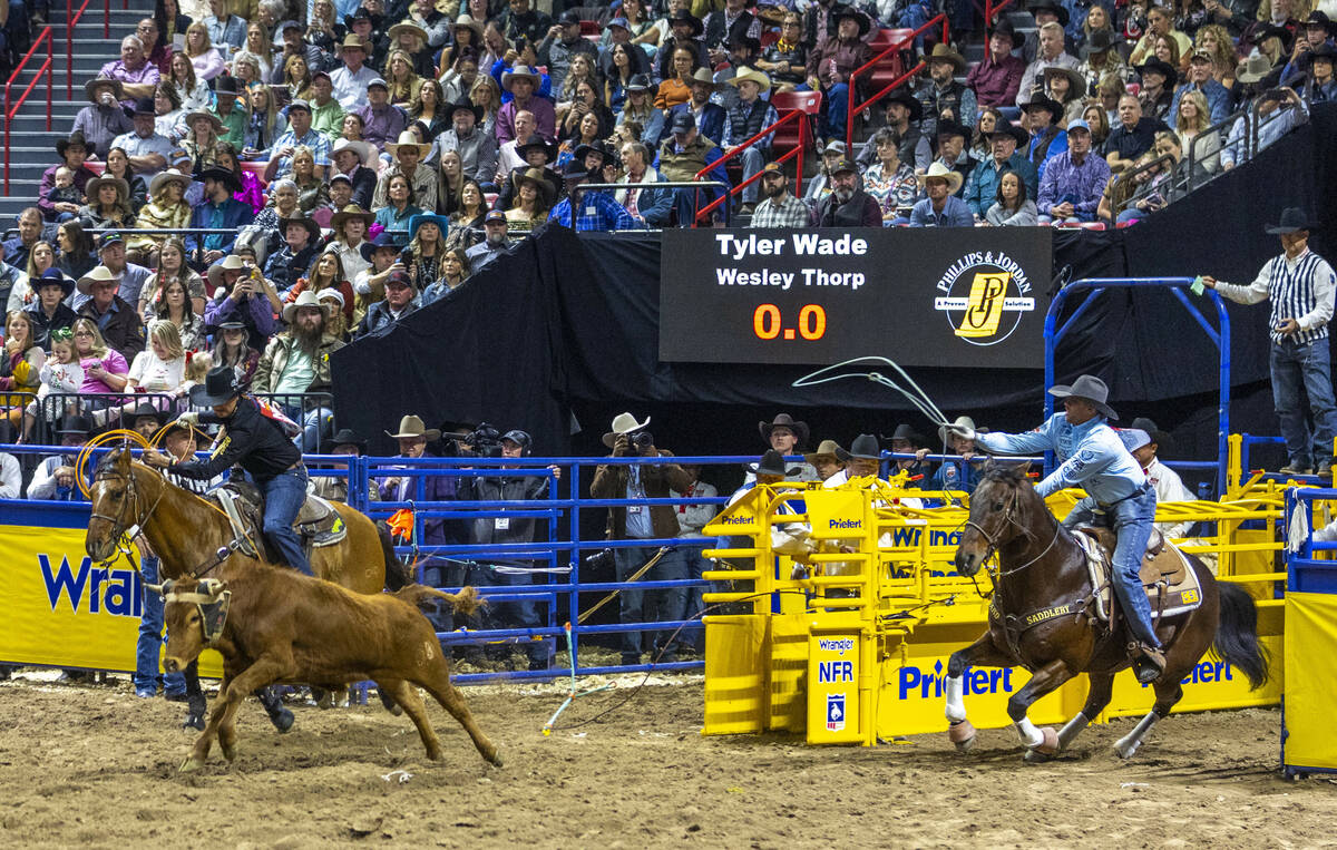 Team roping header Tyler Wade, right, and heeler Wesley Thorp leave the gates bearing down on t ...