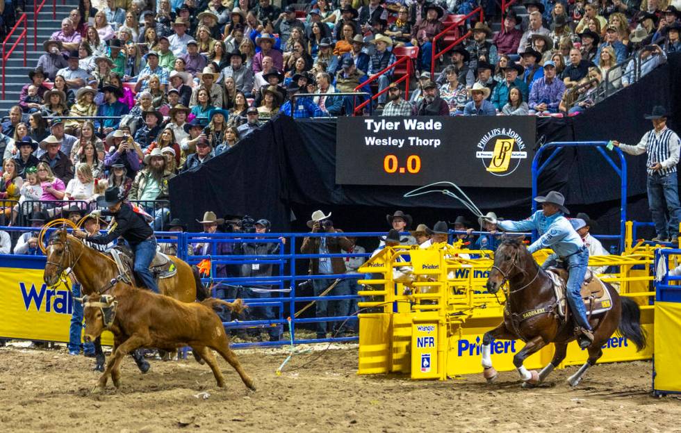 Team roping header Tyler Wade, right, and heeler Wesley Thorp leave the gates bearing down on t ...