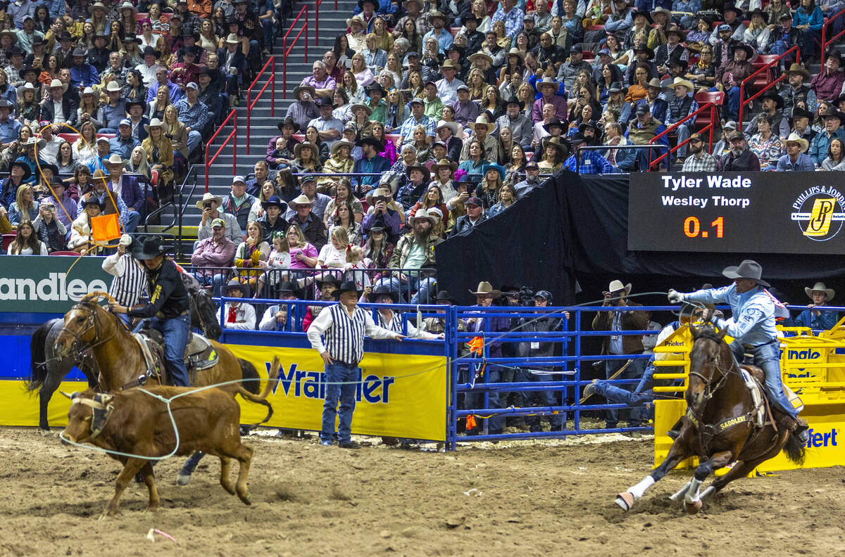 Team roping header Tyler Wade, right, and heeler Wesley Thorp leave the gates bearing down on t ...