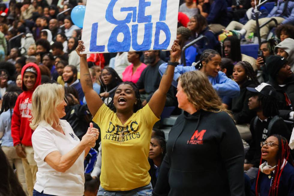 A Democracy Prep fan cheers as she receives a thumbs up from a Mater East fan walking by during ...