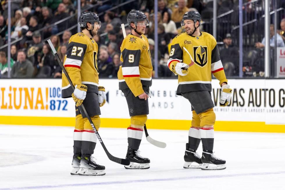 Golden Knights defenseman Shea Theodore (27) and center Jack Eichel (9) listen to center Tomas ...