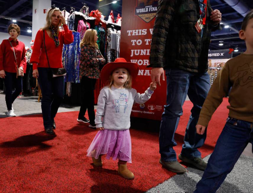 Rainey Wingo, 2, holds on to her father, Will, of Texas, as they shop at Cowboy Christmas at th ...