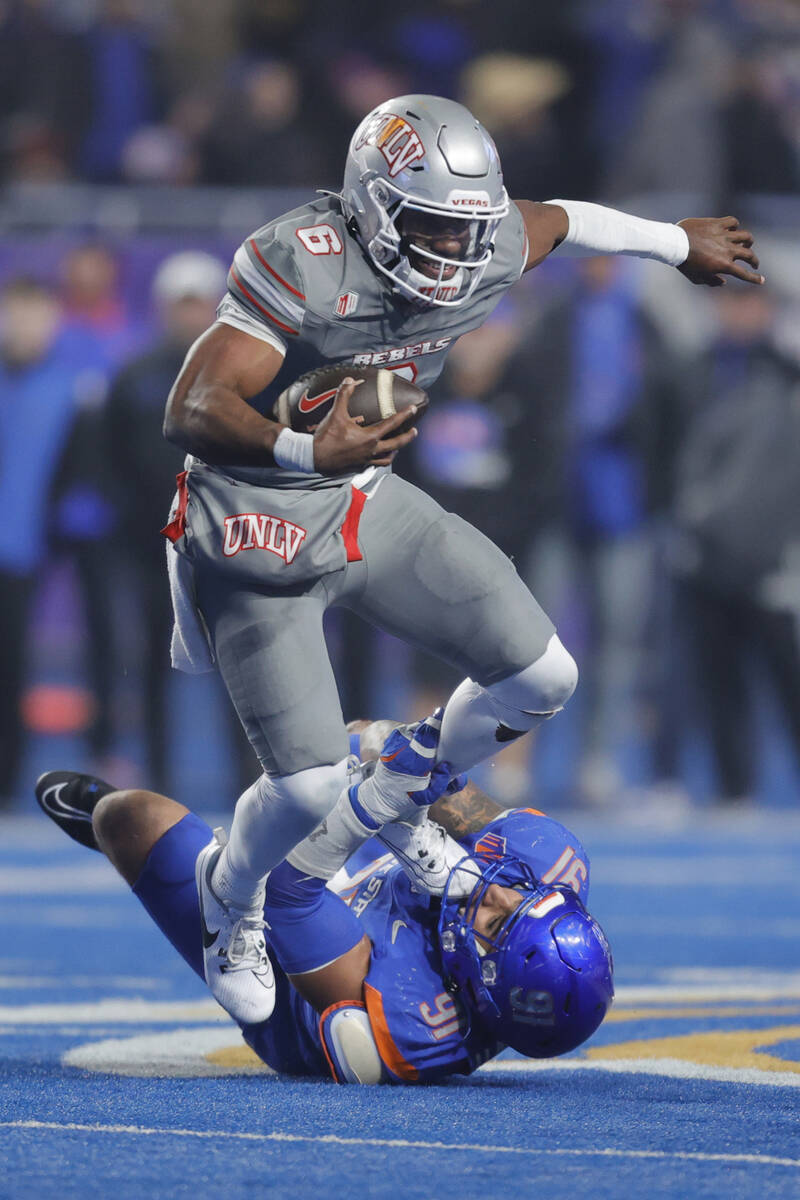 UNLV quarterback Hajj-Malik Williams (6) escapes a tackle attempt by Boise State defensive end ...