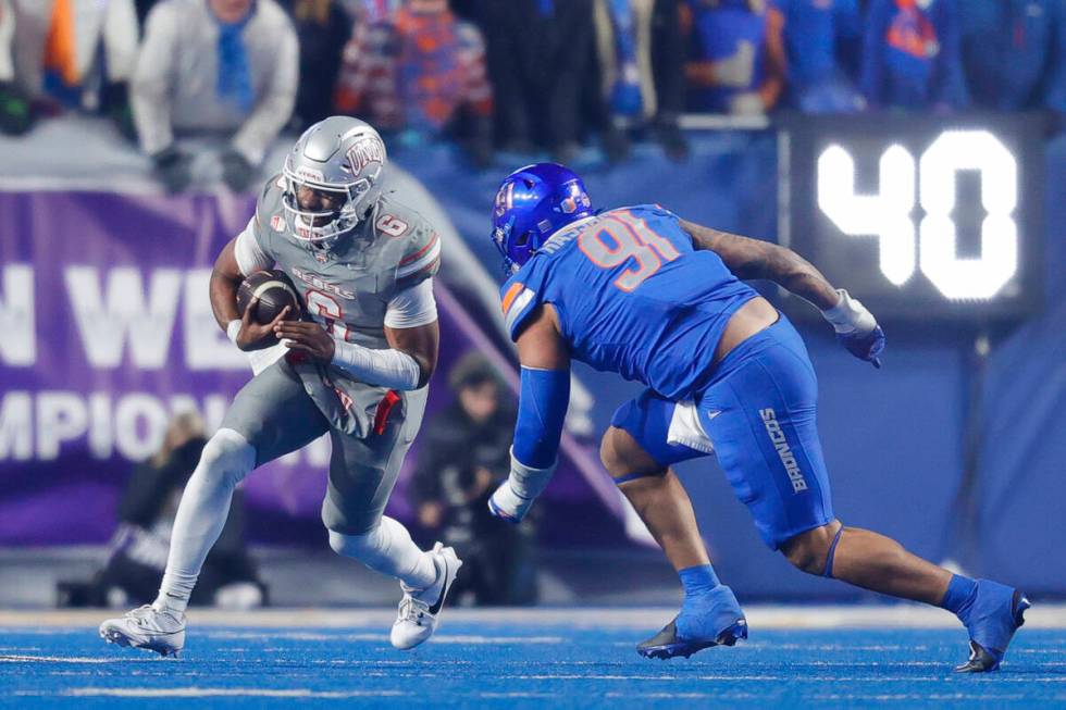 UNLV quarterback Hajj-Malik Williams (6) scrambles with the ball in front of Boise State defens ...