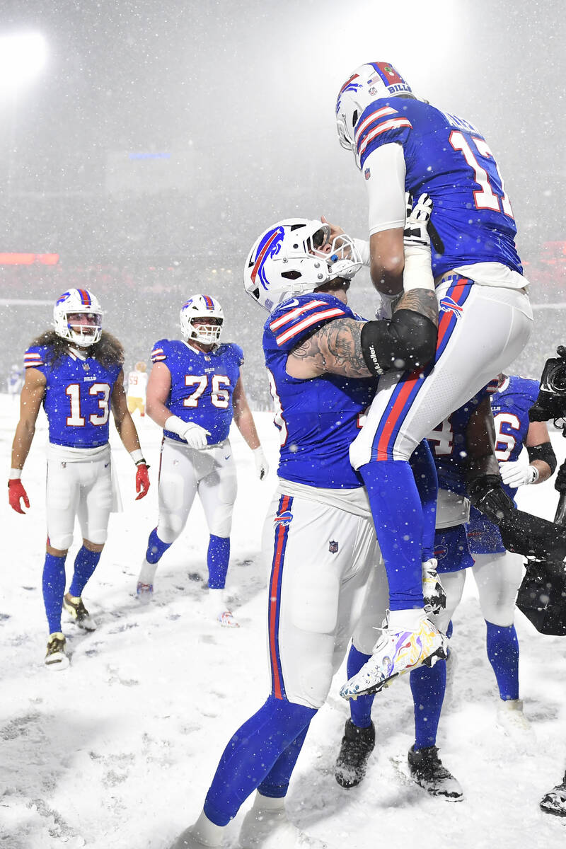 Buffalo Bills quarterback Josh Allen, top right, celebrates with offensive tackle Spencer Brown ...