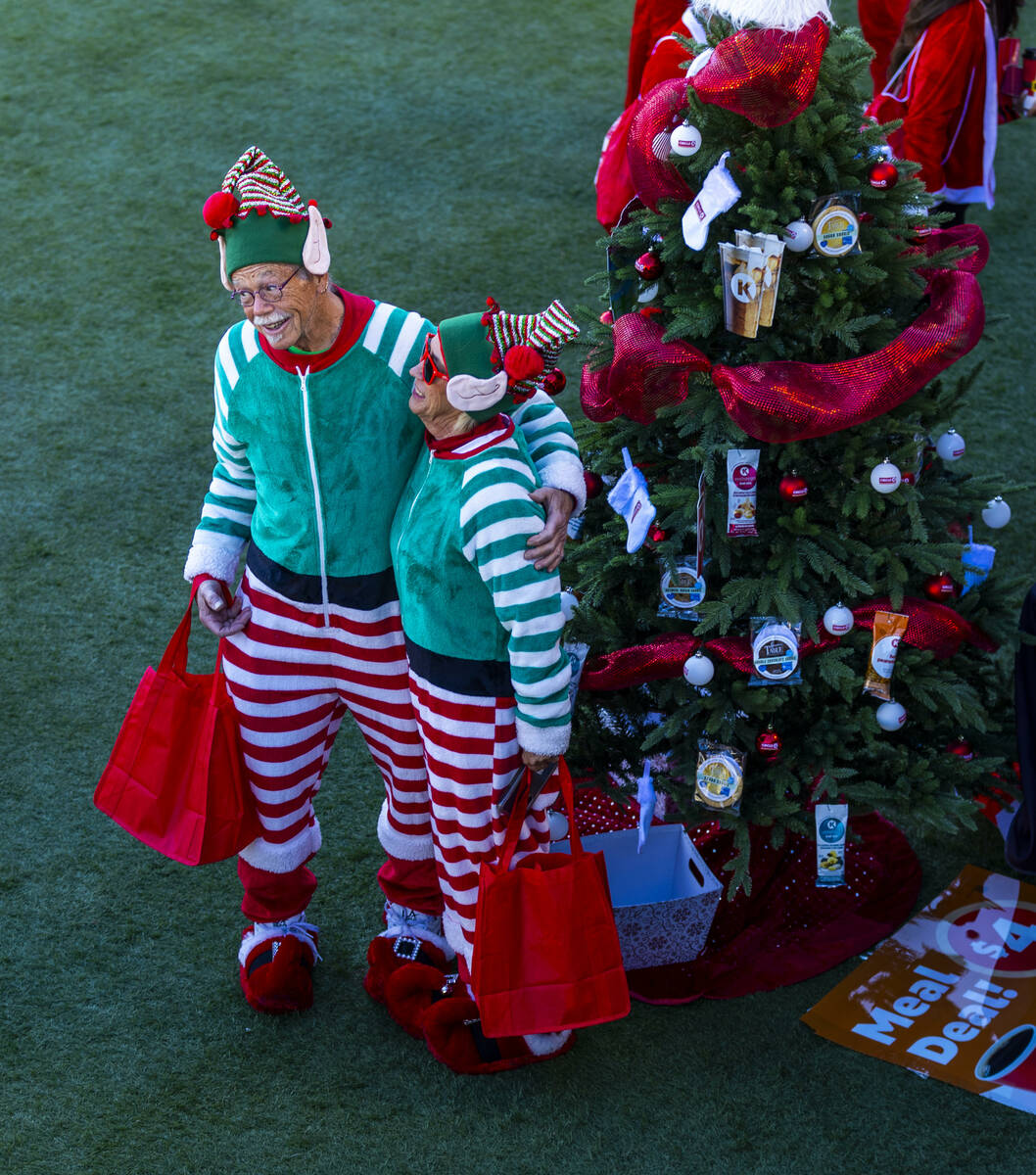 A couple of elves gather near a decorated tree at the Downtown Las Vegas Events Center before t ...