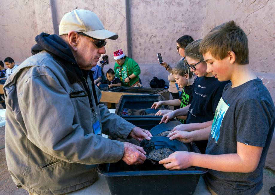 Instructor Bill Durbin helps Bentley Davis, 12, of Layton, Utah, learn the art of panning in a ...