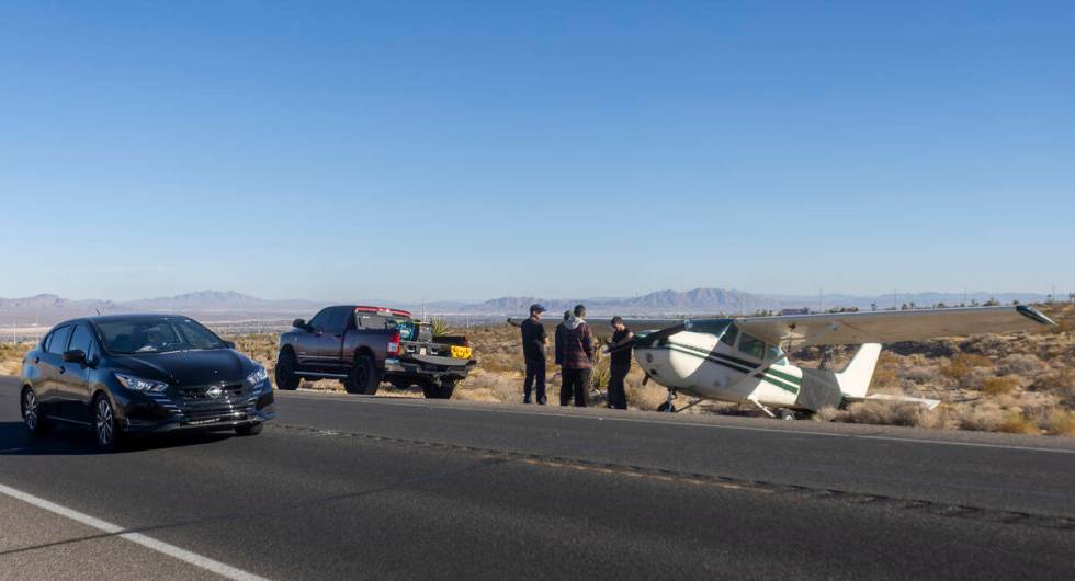 People drive by a plane that emergency landed on Kyle Canyon Road, Saturday, Dec. 7, 2024, in L ...