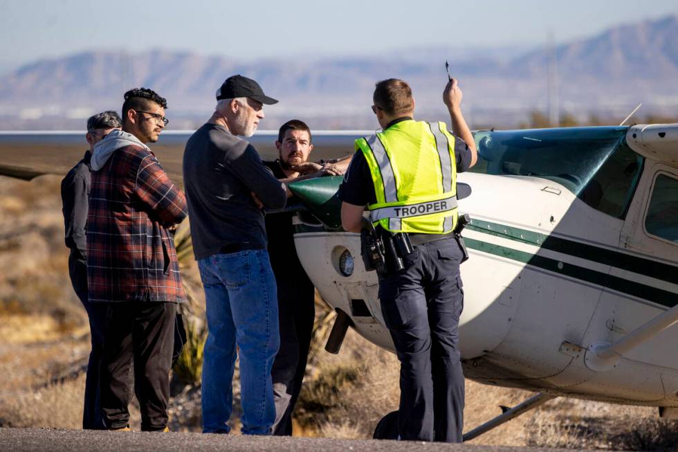 A crew of men, who declined to give their names, talk to Nevada Highway Patrol trooper Roy Eric ...