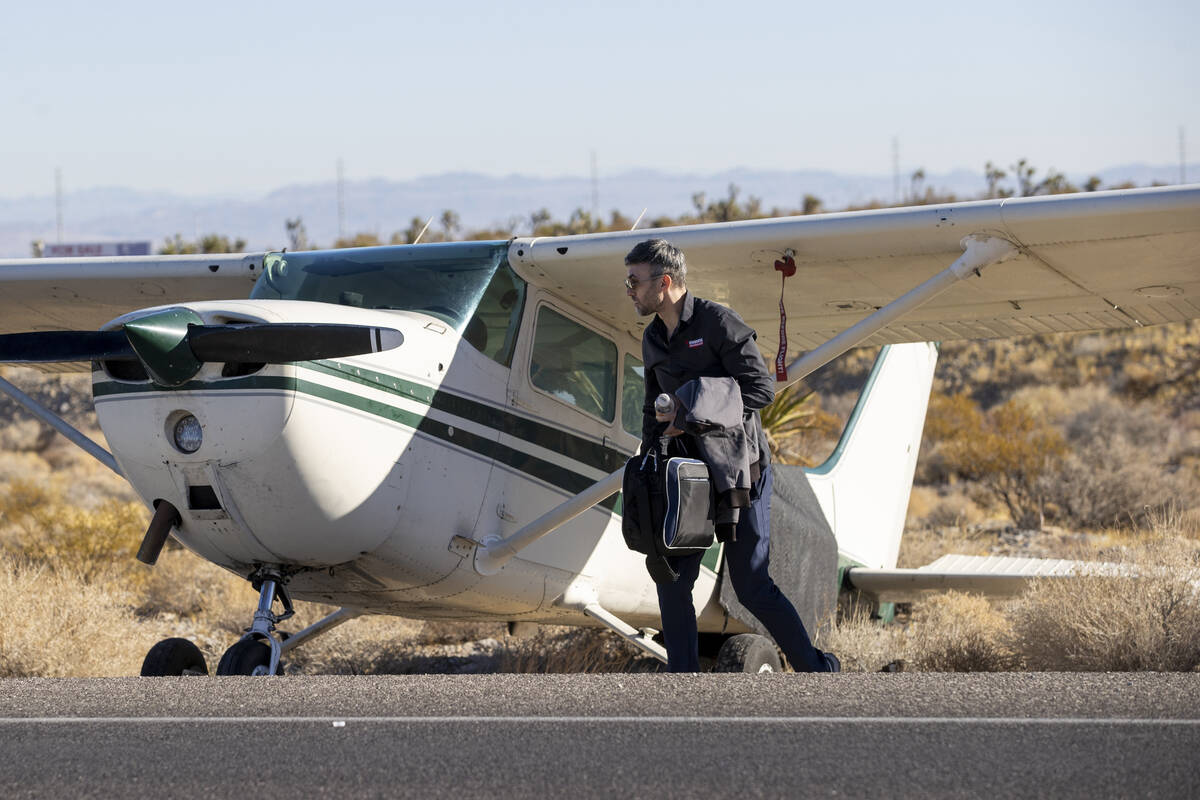 A man, who declined to give his name, grabs belongings out of a plane after the plane emergency ...