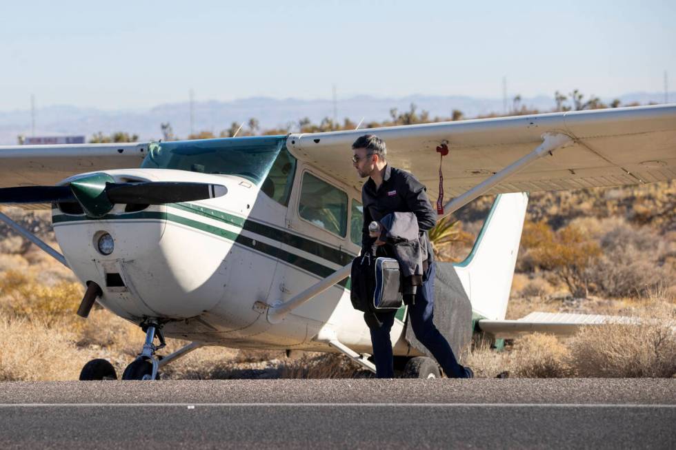 A man, who declined to give his name, grabs belongings out of a plane after the plane emergency ...