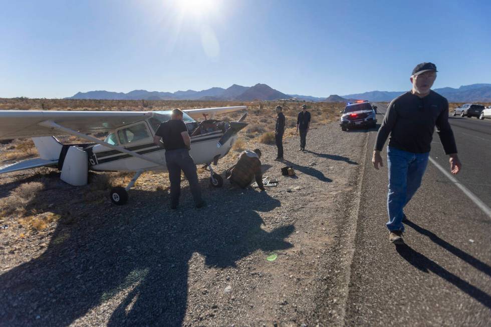 A crew of men, who declined to give their names, work on a plane after it emergency landed on K ...