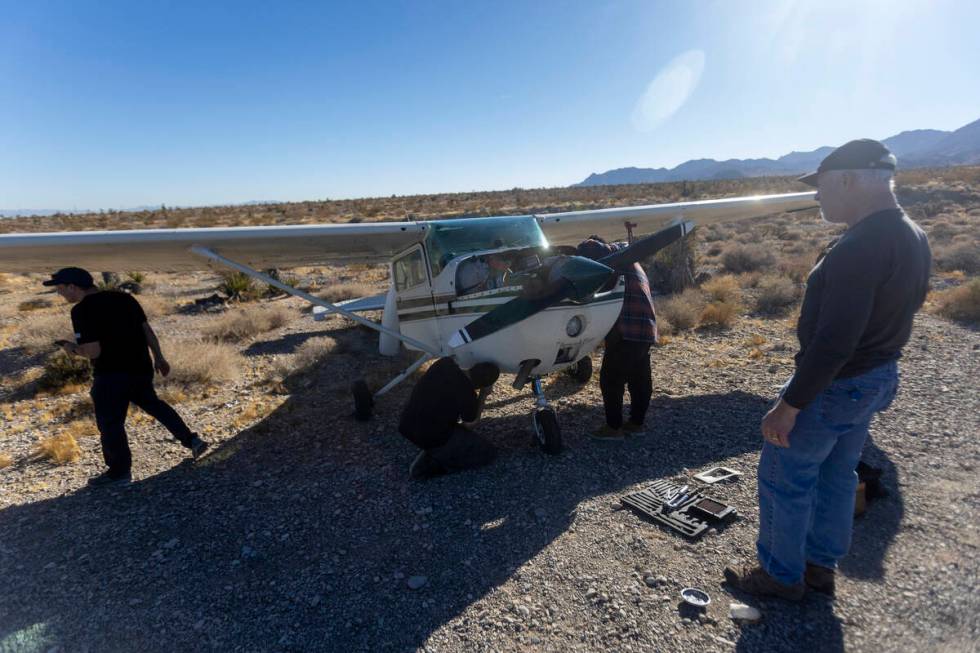 A crew of men, who declined to give their names, work on a plane after it emergency landed on K ...