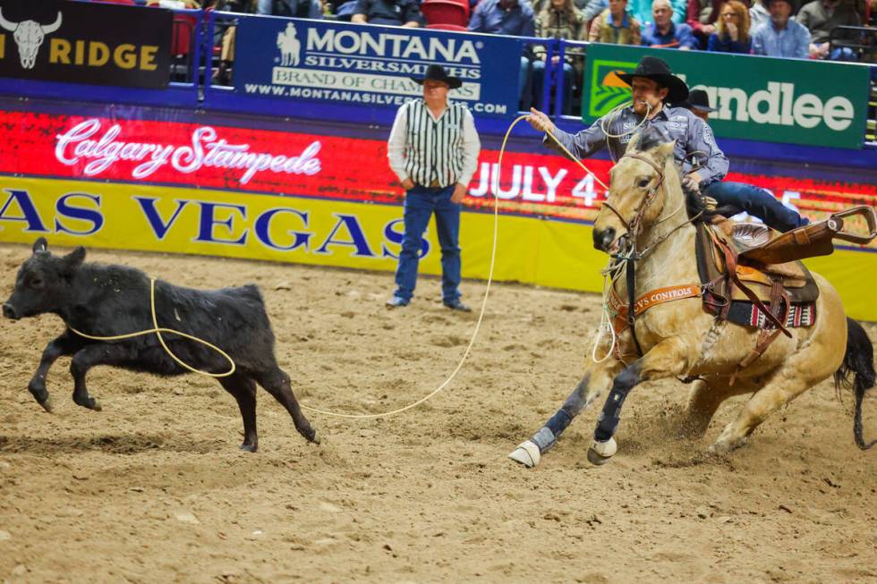 Tie-down roper Joel Harris jumps off his horse to run towards the calf during round three of th ...