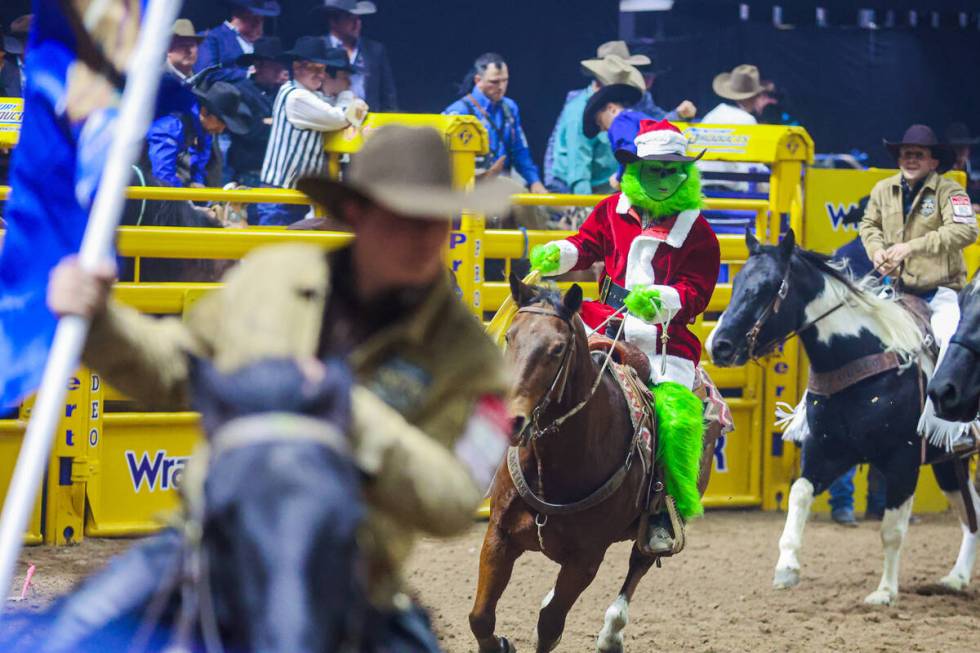 Bull rider Jeter Lawrence rides out onto the dirt dressed like the Grinch during round three of ...