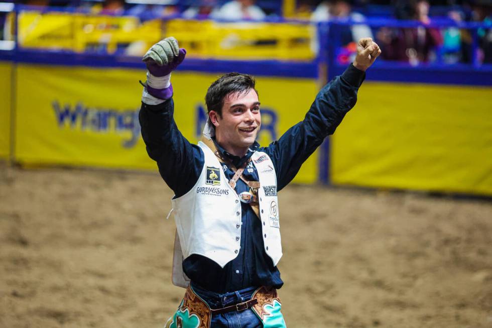 Bareback rider Bradley Miller pumps his fists after his ride during round three of the National ...